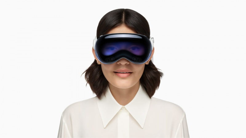  Jauna moteris biuro aprangoje, dėvi „Apple“.'s Vision Pro headset on her face, set against a solid white background